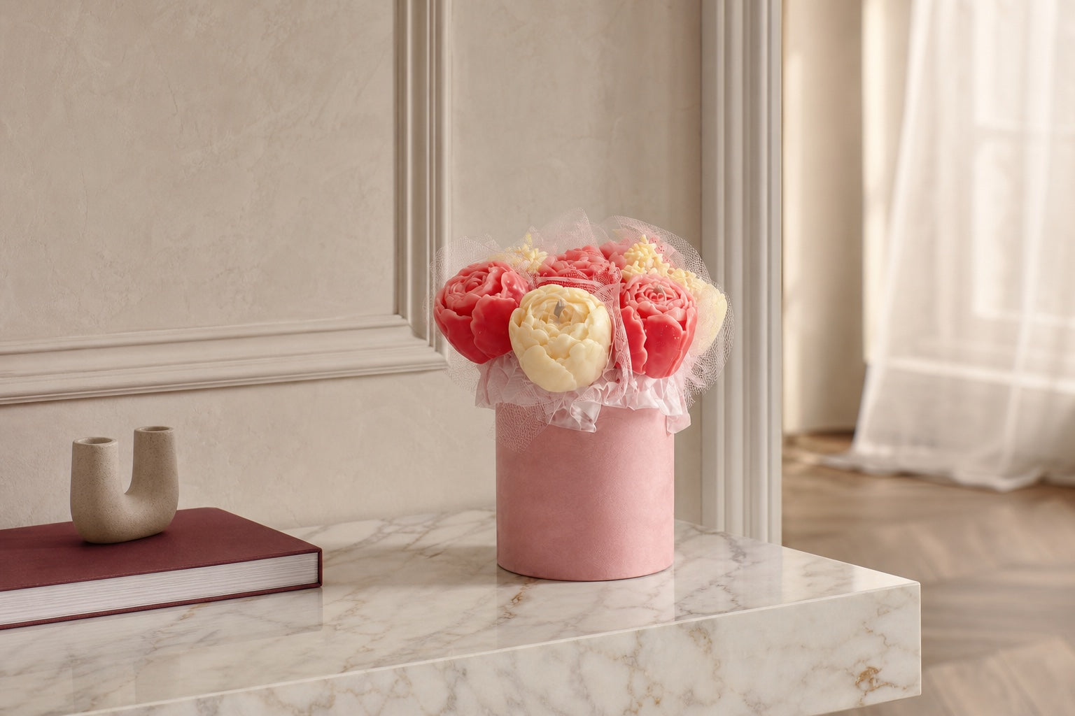 An unlit blush and ivory floral candle bouquet displayed as an art object on a marble console