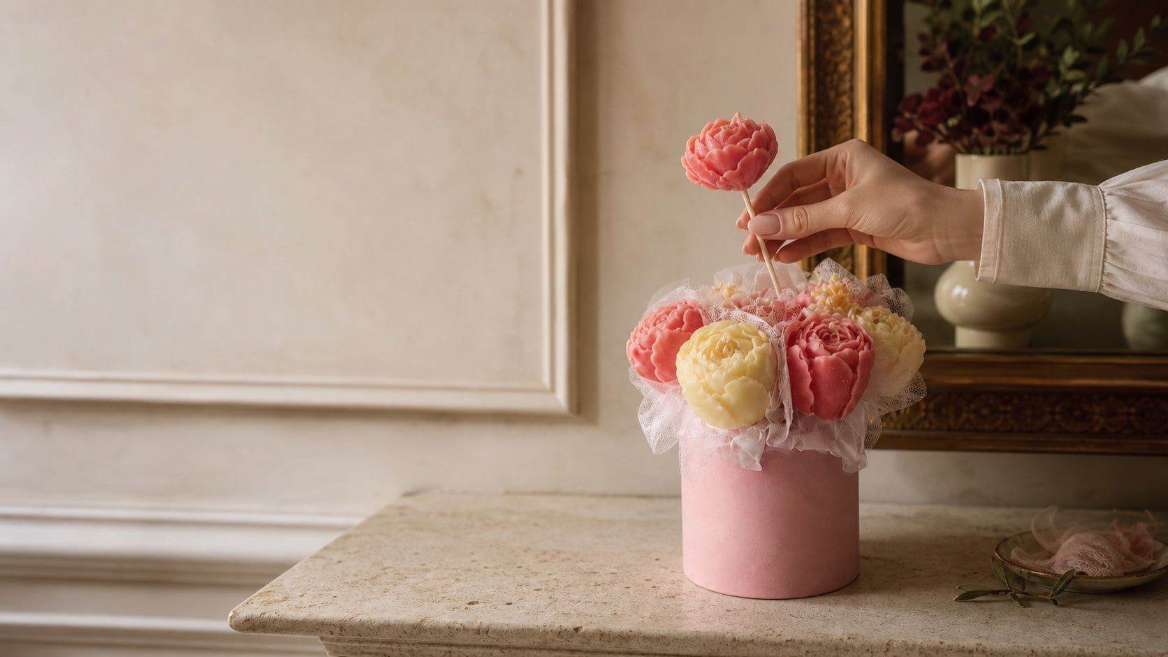A single wax flower being lifted from a floral candle bouquet