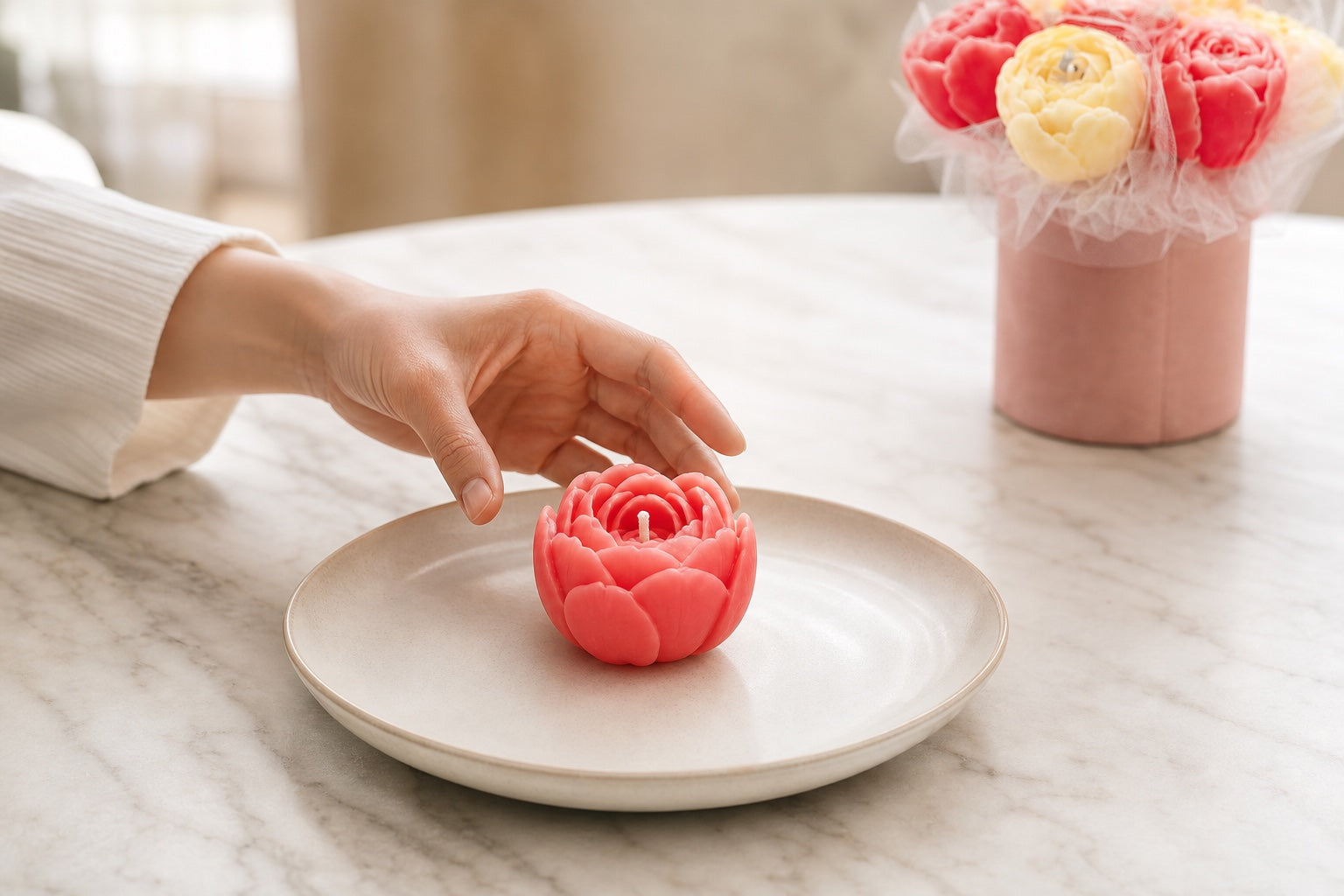 An unlit coral wax flower candle placed upright in the centre of a wide heat-resistant ceramic plate